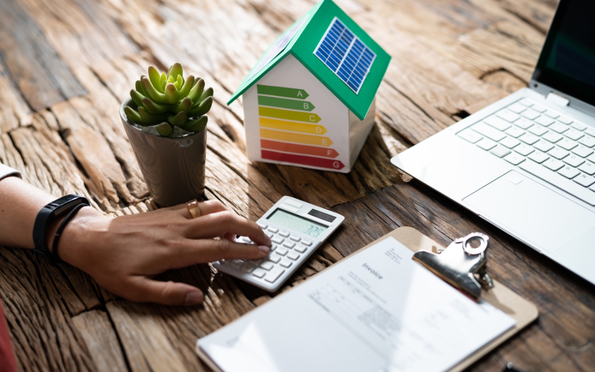 A Person Using A Calculator On A Desk